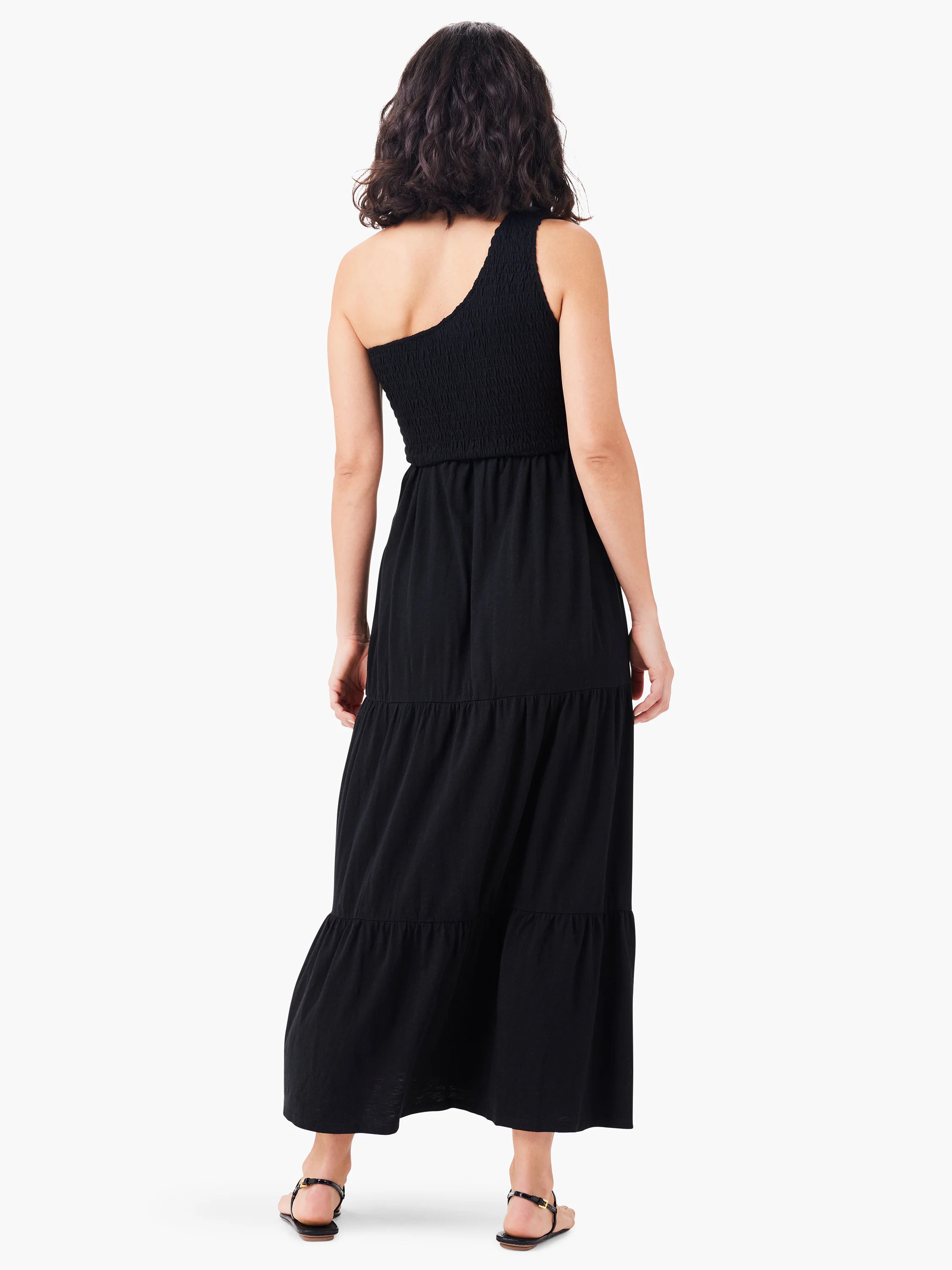 Black tiered maxi dress, one-shoulder neckline, smocked bodice.  Back view.