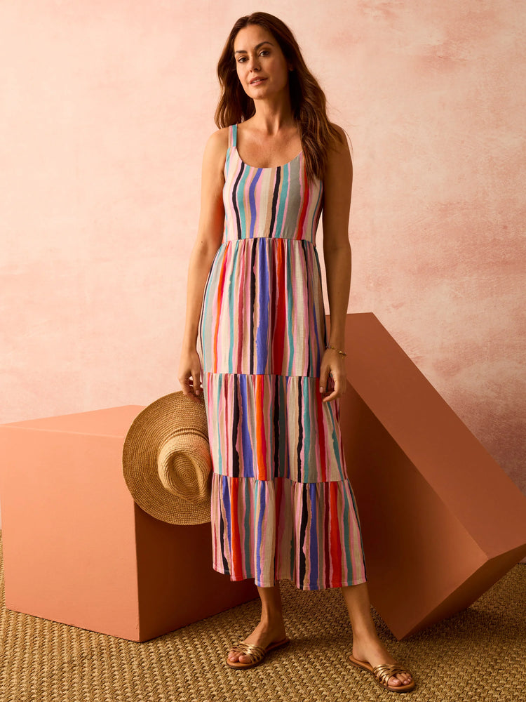 Multicolored vertical stripes on a tiered maxi dress.  Off-white background. Pink, red, blue, and teal stripes.  Sleeveless.