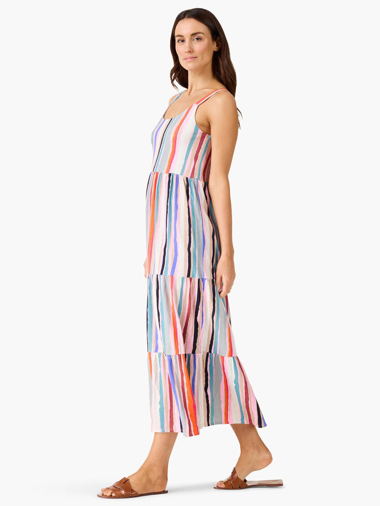 Multicolored tiered maxi dress with vertical stripes in pink, orange, blue, and teal on a cream background.  Sleeveless,...
