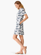 White t-shirt dress with teal/grey leaf print, short sleeves, and pockets.