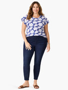 Blue short-sleeve shirt with white leaf pattern, dark denim leggings, brown sandals.