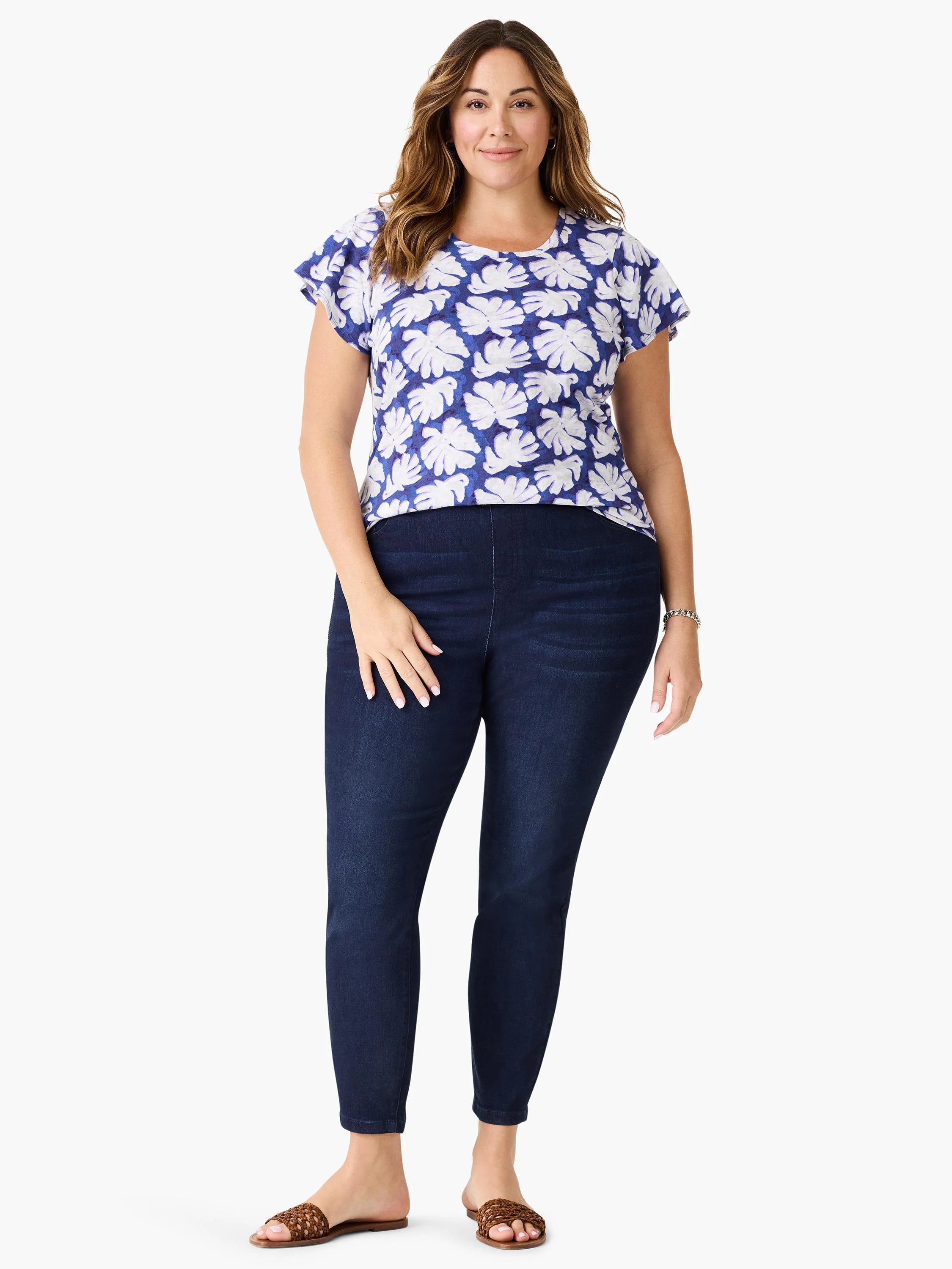 Blue short-sleeve shirt with white leaf pattern, dark denim leggings, brown sandals.