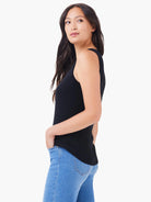 Black boatneck tank top; sleeveless, fitted.  Model shown wearing light blue jeans.