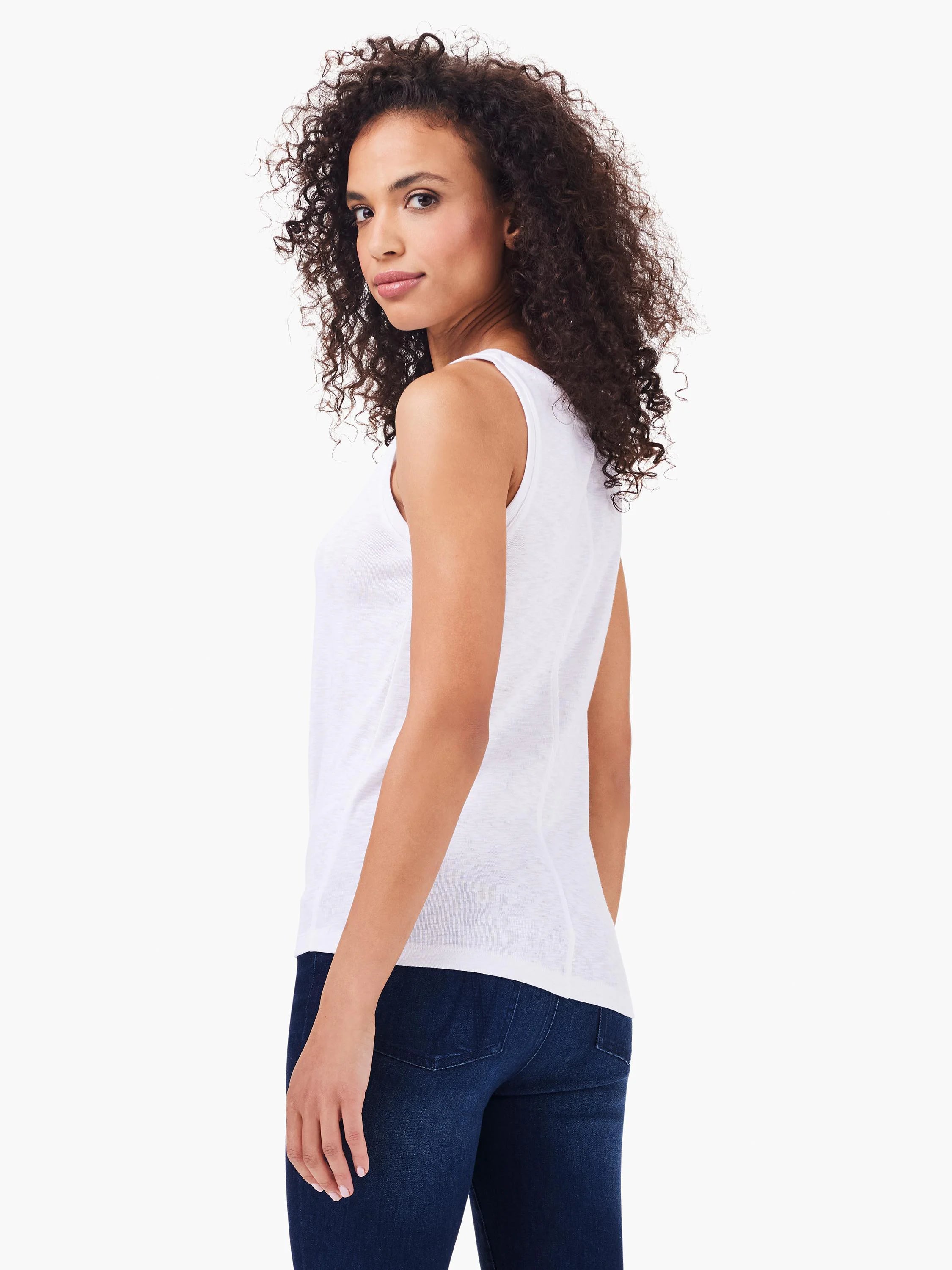 White boatneck sleeveless top, shown from the back.  Model wears dark wash jeans.