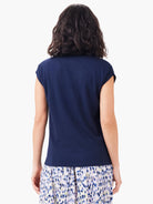 Dark navy blue V-neck tank top, short sleeves.  Model shown from behind, wearing a patterned skirt.