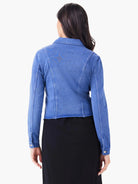 Back view of a model in a blue denim-look jacket with fitted seams, raw hem, and buttoned cuffs.