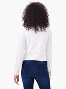 White denim-style jacket, seen from behind, with tan contrast stitching, stand collar, and raw hem.