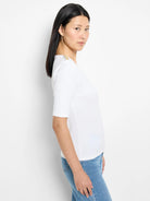 White ribbed, elbow-length sleeve top with gold buttons on shoulders.