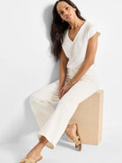 Cream V-neck tank top with short cap sleeves.