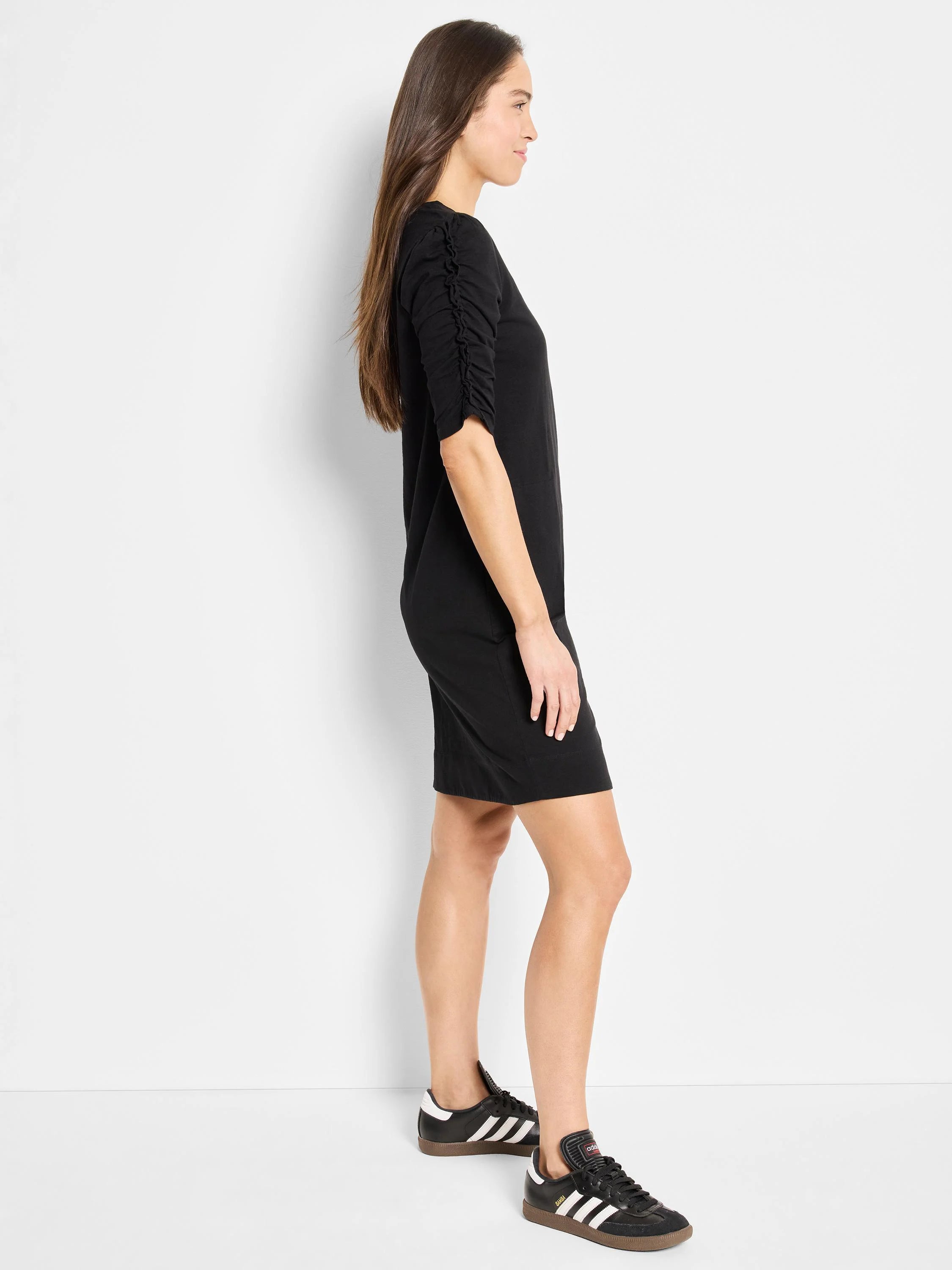 Black elbow-sleeve mini dress; ruched detail on sleeves.