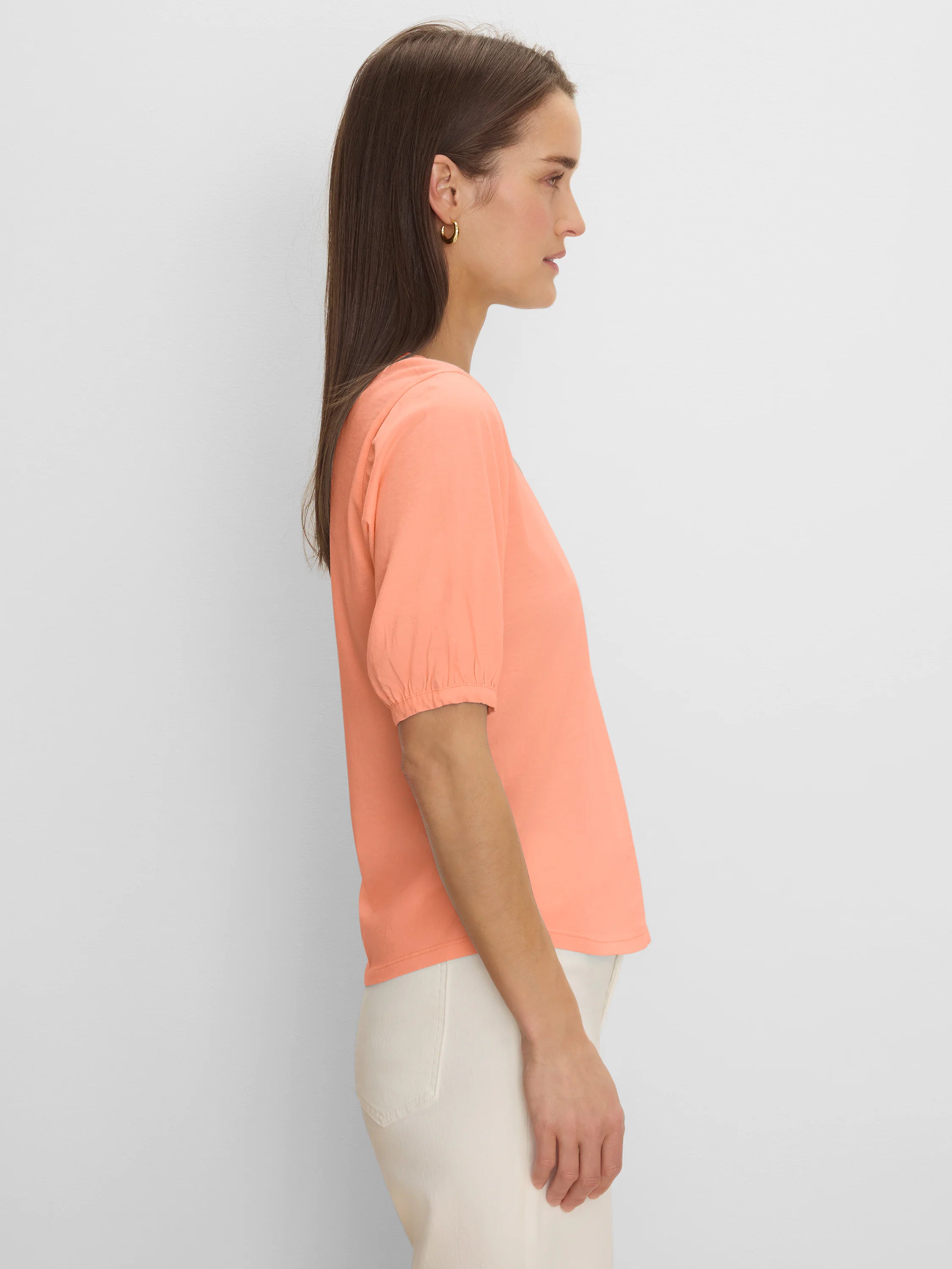Peach elbow sleeve tee with gathered cuffs, worn by a model in profile.