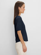Dark blue V-neck tee with elbow sleeves and gathered cuffs, worn by model in profile.