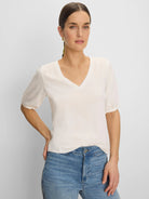 Off-white V-neck tee with elbow-length sleeves gathered at the cuff.