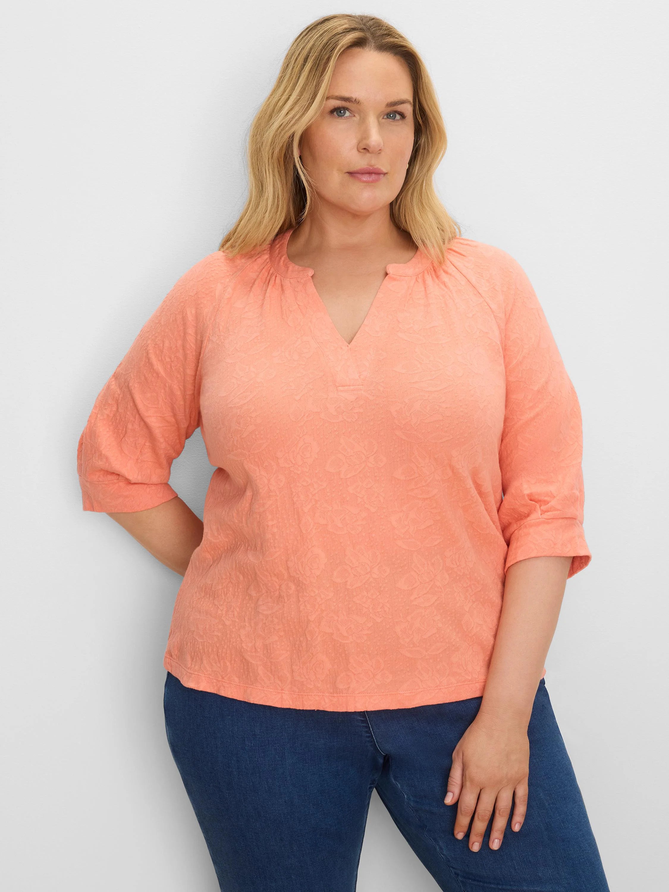 Peach floral lace knit split neck top with cuffed three-quarter sleeves.