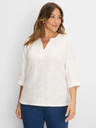 Off-white, relaxed-fit lace knit top with subtle floral texture, split V-neck, and 3/4 cuffed sleeves.