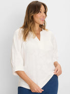 Off-white lace knit top with a split V-neck and 3/4 cuffed sleeves, shown on a model.