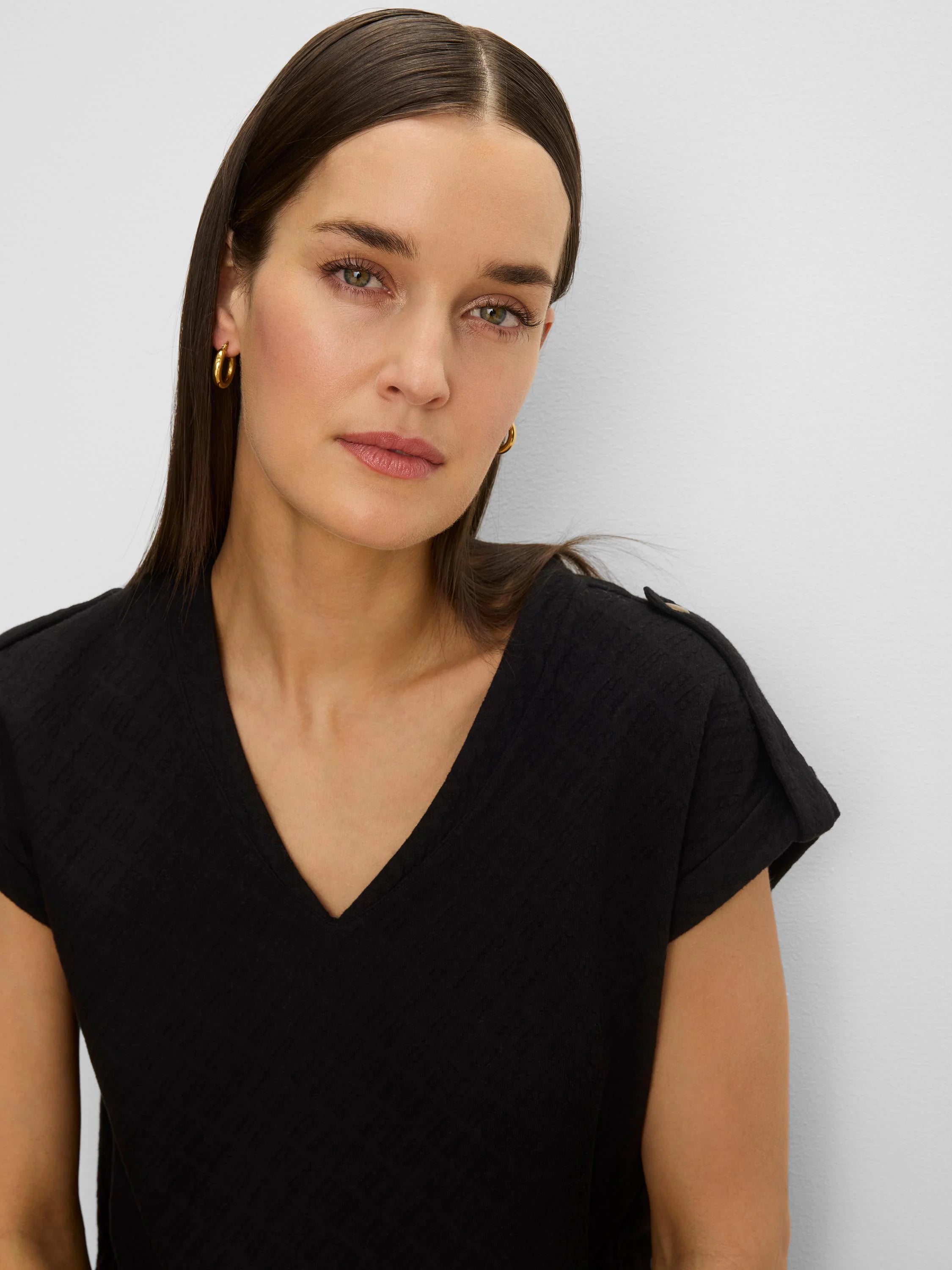 Black lace knit tee with V-neck and rolled cap sleeves.