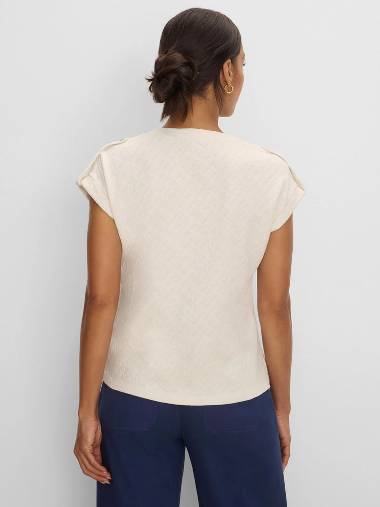 Cream lace knit tee with raised geometric texture and cap sleeves, shown from the back on model.
