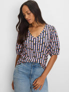 V-neck, elbow-sleeve tee with a multi-colored checkered pattern in navy, light blue, pink, and green.