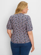 Navy, coral, light blue, and green checkered tee with puffed sleeves, shown on a model from the back-right.