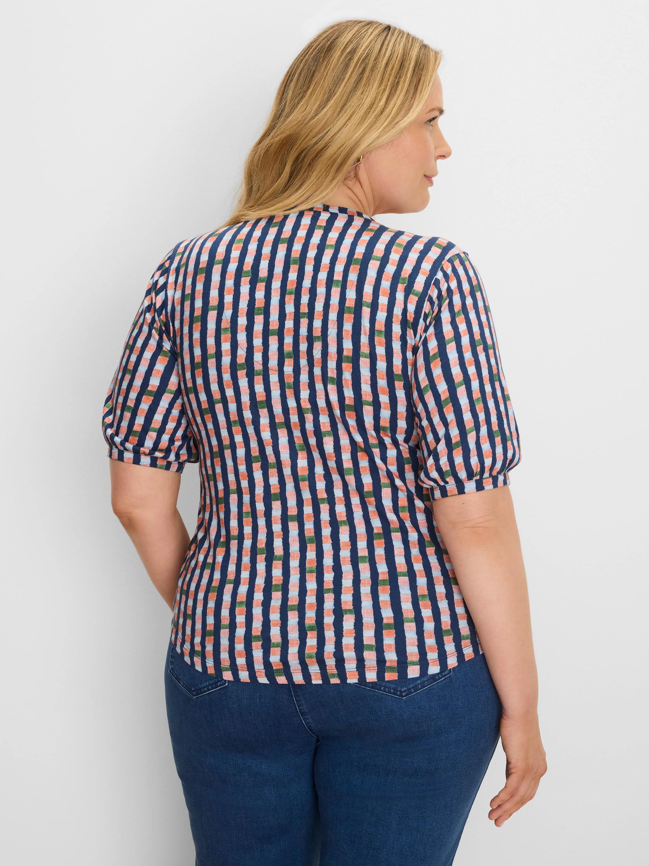 Navy, coral, light blue, and green checkered tee with puffed sleeves, shown on a model from the back-right.
