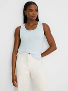 Light blue cotton slub tank with a soft ruffled scoop neck. Model wears it.