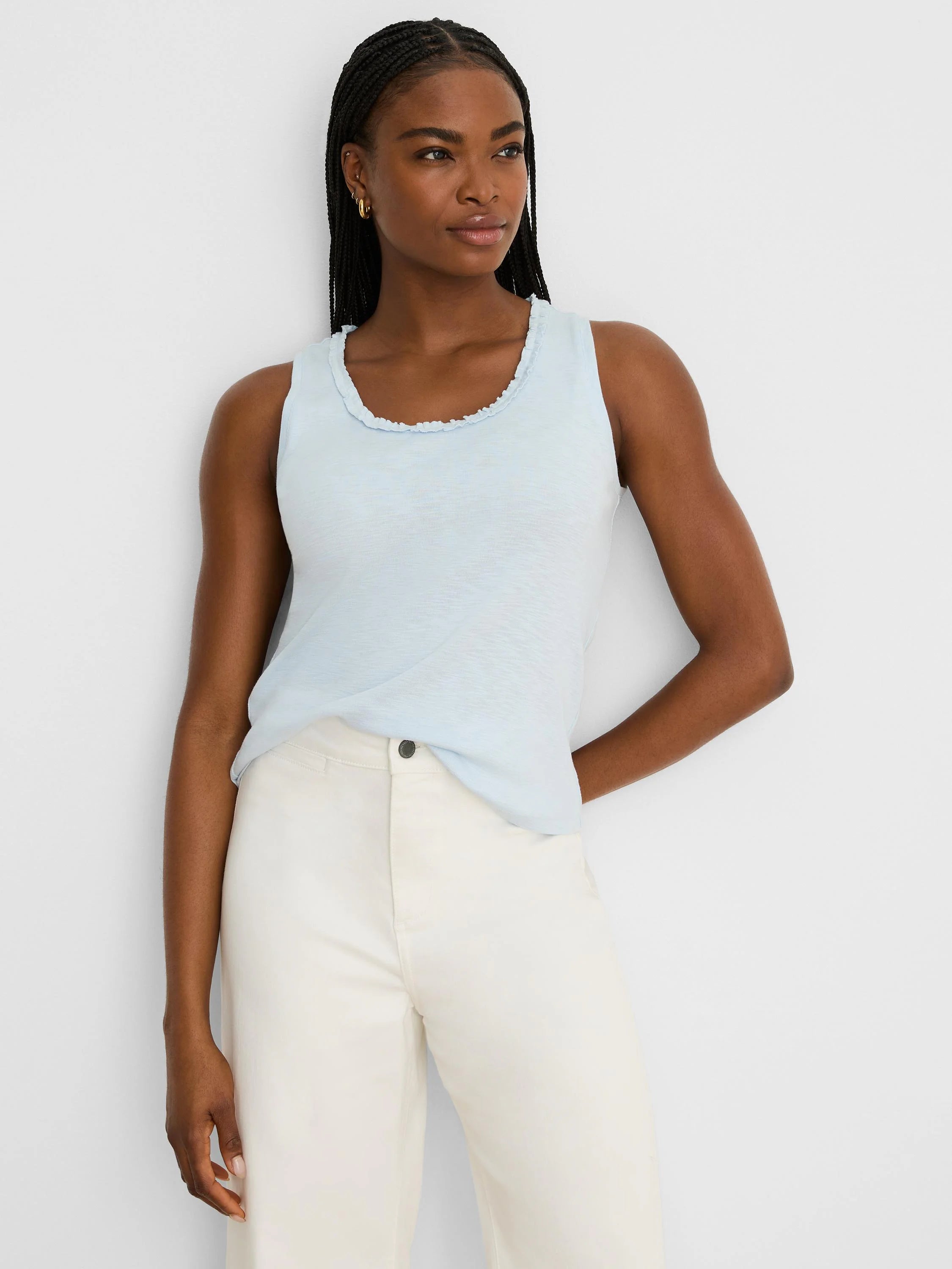 Light blue cotton slub tank with a soft ruffled scoop neck. Model wears it.
