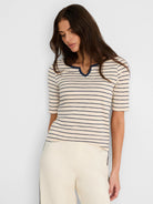 Off-white elbow-sleeve top with navy horizontal stripes and a V-notch neck.