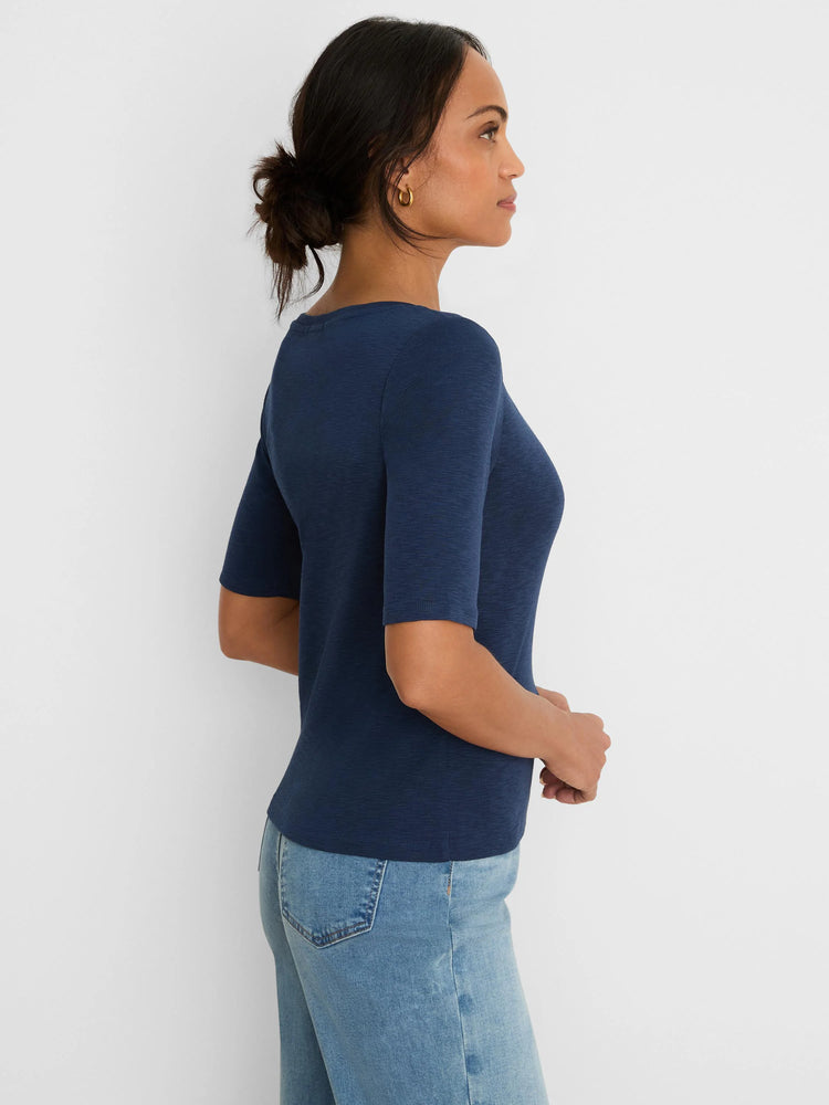 Navy fitted elbow-sleeve notch tee with a subtle V-neckline, worn by a woman in a side profile view.