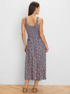 Back view of sleeveless midi knit dress with scoop back. Blue, peach, light blue, & green reef stripe pattern.
