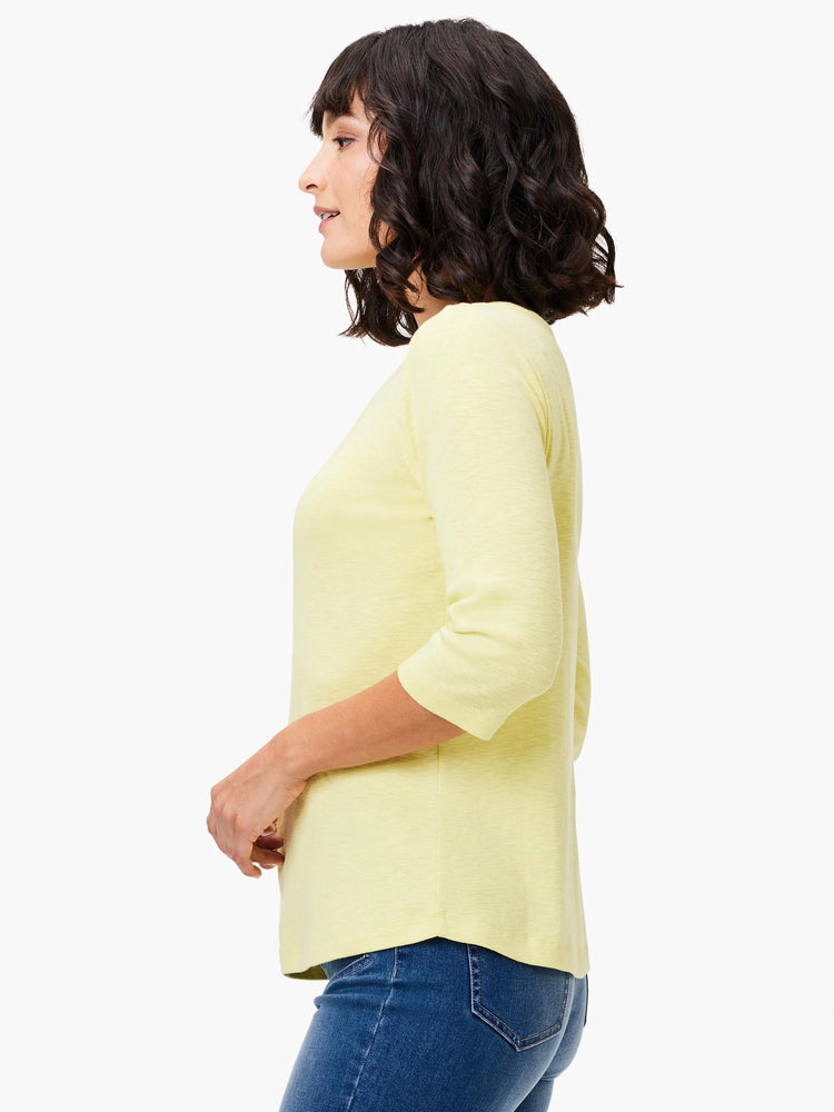 Pale yellow 3/4 sleeve tee with a heathered texture, shown on a woman from the side.