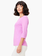 Model in a pink 3/4 sleeve boat tee made of a subtle heathered knit.