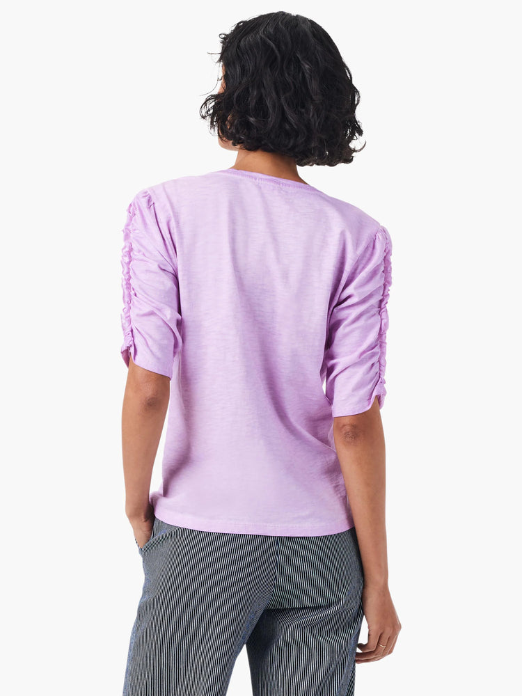 Lilac shirt, elbow-length sleeves with ruched detailing, split neckline.  Back view.