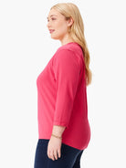 Fuchsia V-neck tee with 3/4 rolled sleeves, shown on a model in profile.