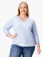 Pale blue 3/4 sleeve V-neck tee with rolled cuffs, worn by a model.