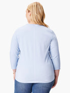 Light blue 3/4 sleeve tee with rolled cuffs and a visible vertical seam down the back. Model seen from behind.