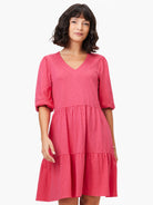 Pink tiered mini dress with a V-neck and elbow-length sleeves.