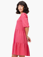 Pink tiered V-neck mini dress, 3/4 sleeves, textured fabric.