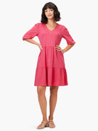 Pink tiered mini dress, V-neck, elbow-length sleeves.