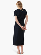 Black midi dress, short sleeves, side slits, shown from the back.
