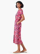 Pink midi dress with purple and orange floral print, short sleeves, and side pockets.