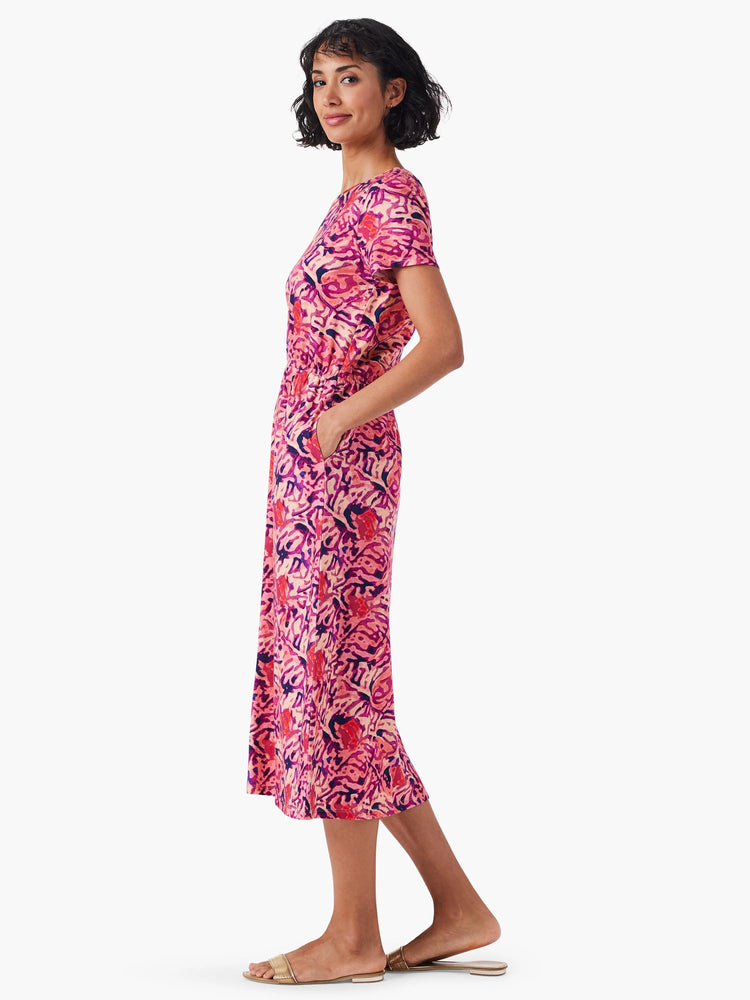 Pink midi dress with purple and orange floral print, short sleeves, and side pockets.