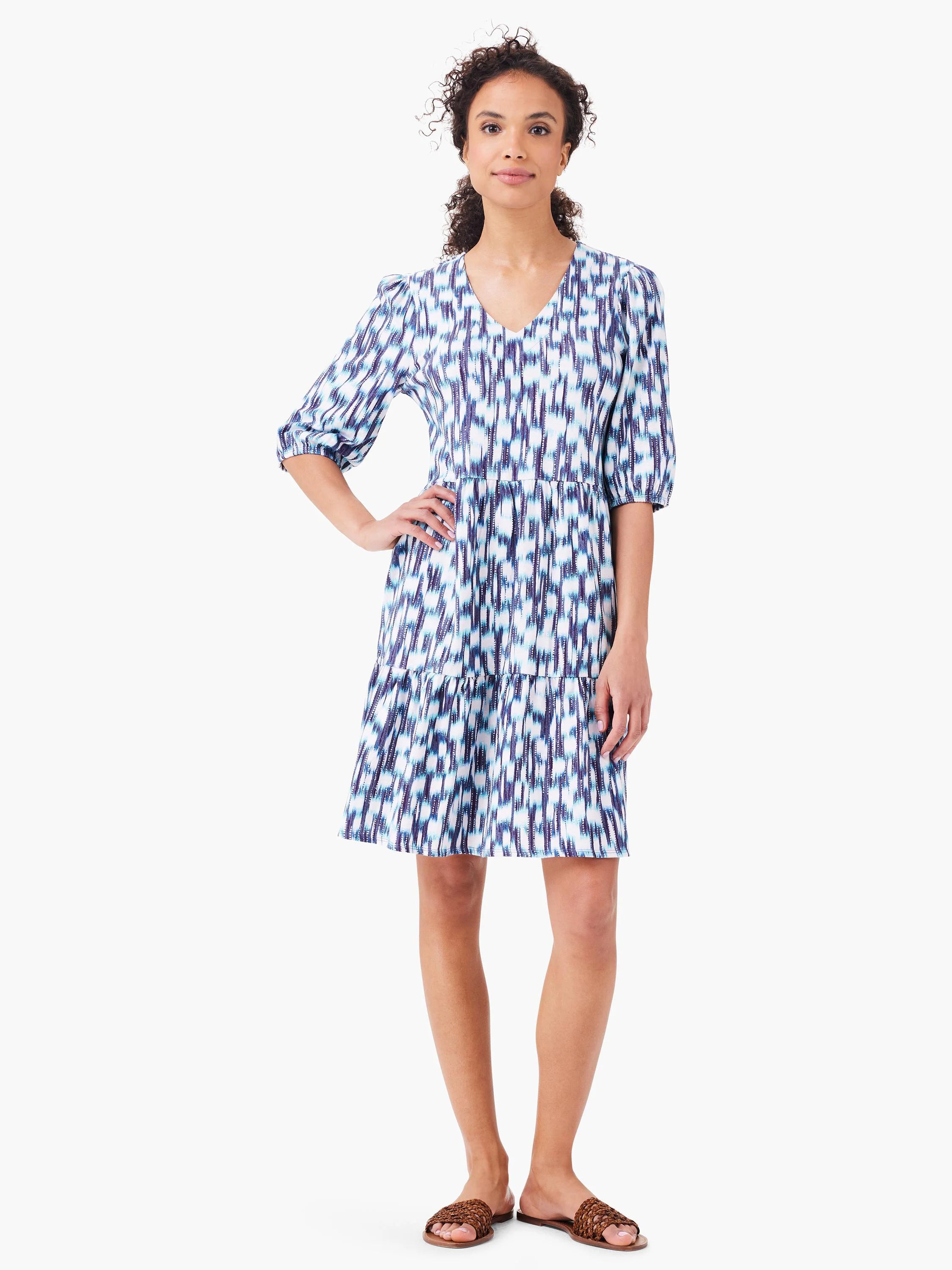 White tiered mini dress with blue and purple abstract print.  V-neck, elbow-length sleeves.