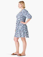 White tiered dress with teal, blue, and purple abstract print.  Elbow-length sleeves, V-neck.