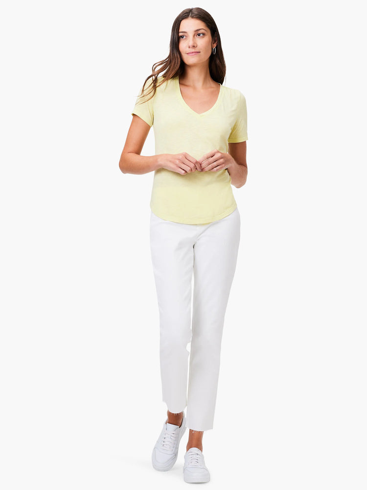 Pale yellow short-sleeve V-neck tee modeled by a woman, showing its relaxed fit and curved hemline.