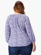 3/4 sleeve top, white background with purple and blue medallion pattern.  Split neckline.