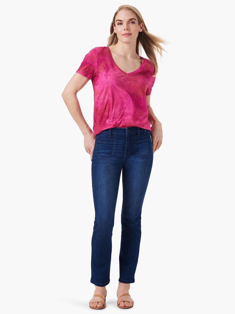 Pink V-neck short-sleeve shirt with mottled texture, paired with dark wash straight-leg jeans.
