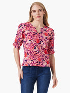 Pink, red, and purple abstract print top.  Three-quarter sleeves, ruched detail, V-neck.