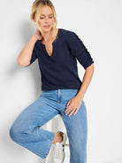 Navy blue, elbow-length sleeves with ruched detailing at the shoulders, split V-neck.