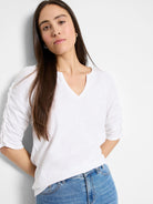White, elbow-sleeve t-shirt.  Split neckline, ruched sleeves.